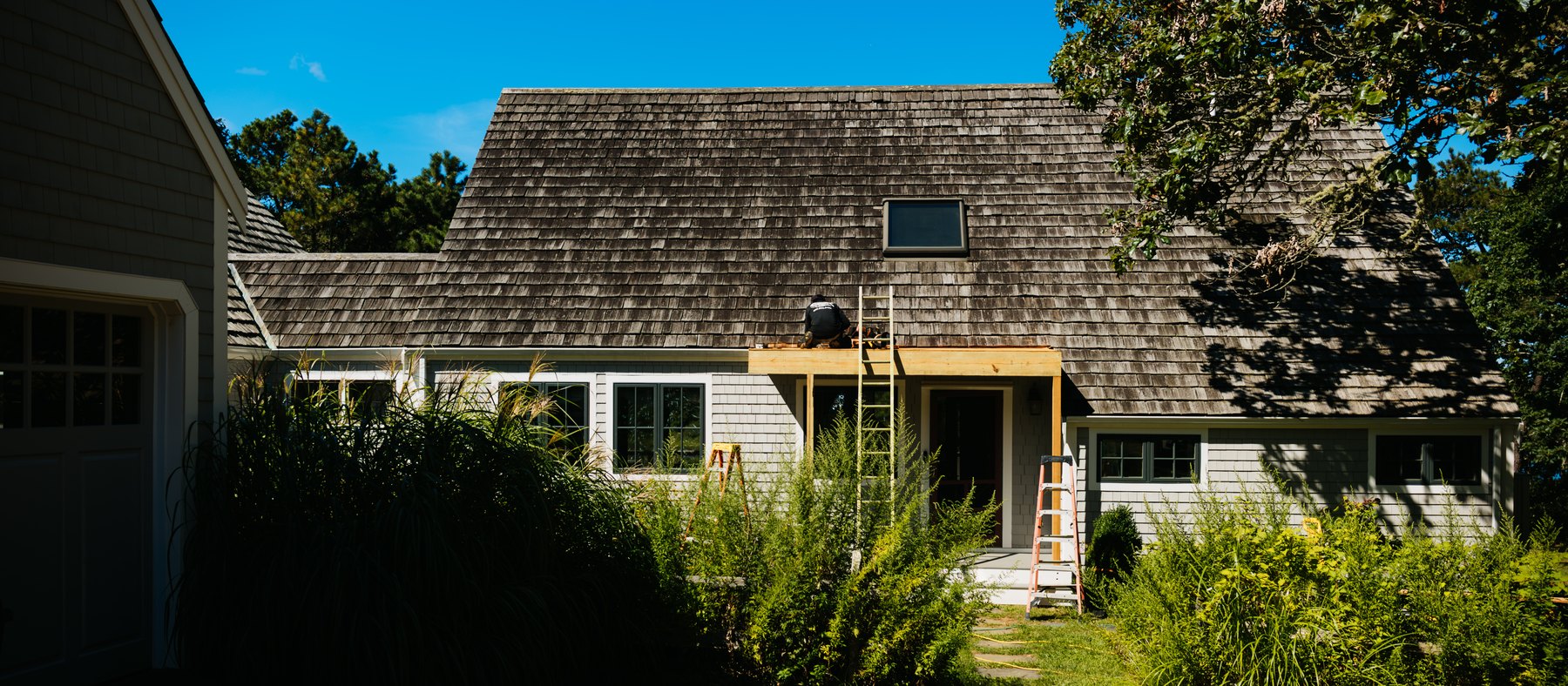 Caleb's Pond House — the entry front, with the new cedar porch going up over the door