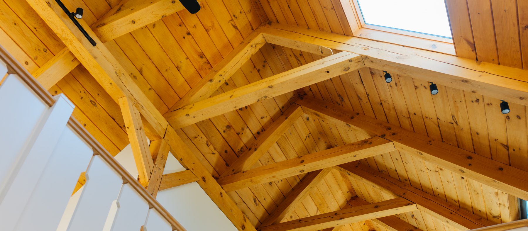 Caleb's Pond House — the pine trusses and the skylight above the gallery rail