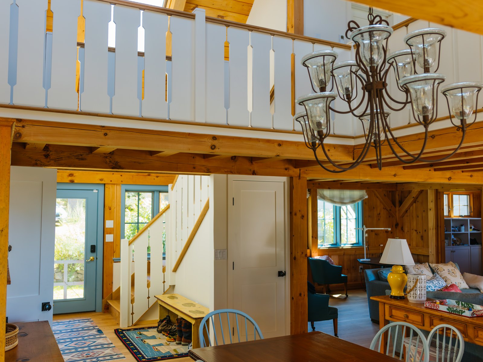 Caleb's Pond House — the double-height hall, the gallery rail and the rooms beyond