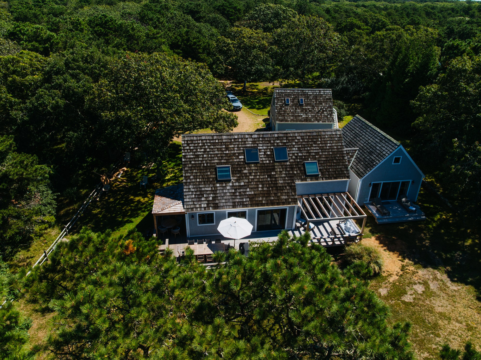 Caleb's Pond House — the shingled house and its deck, set in the oaks above the pond